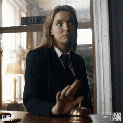 Woman In Suit And Tie At Desk With Exit Sign GIF