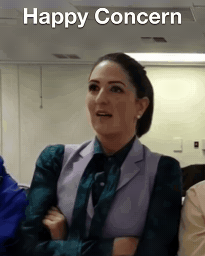 Woman In Suit And Tie Saying Happy Concern GIF