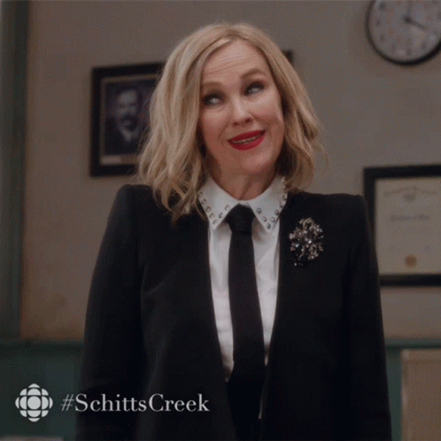 Woman in Suit and Tie Smiling With Schitts Creek