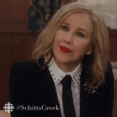 Woman in Suit and Tie With Schitts Creek Hashtag