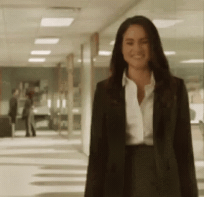 Woman In Suit And White Shirt Standing In Hallway GIF