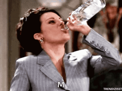 Woman In Suit Drinking Bottle GIF