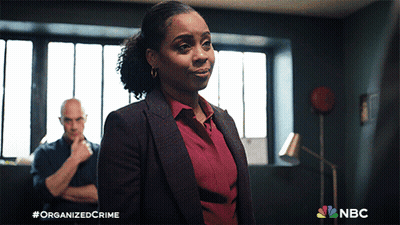 Woman In Suit Facing Man With Arms Crossed NBC Logo GIF