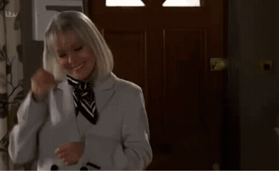 Woman In Suit Holding Phone To Neck GIF