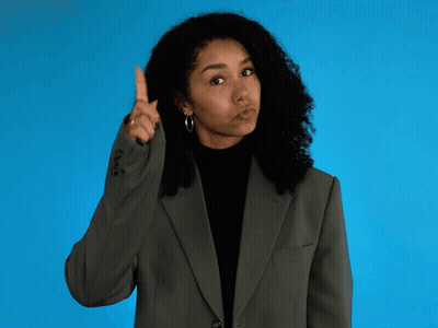 Woman In Suit Pointing Upward GIF