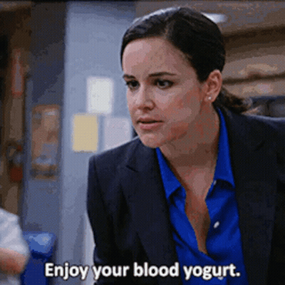 Woman In Suit Saying Enjoy Your Blood Yogurt GIF
