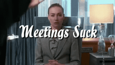 Woman In Suit Sitting In Front Of Meetings Suck Sign GIF