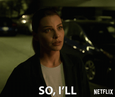 Woman In Suit Standing Before Netflix Sign GIF