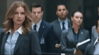 Woman In Suit Standing In Crowd GIF