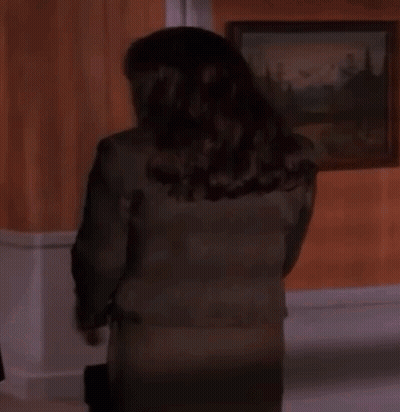 Woman In Suit Standing In Front Of Painting GIF