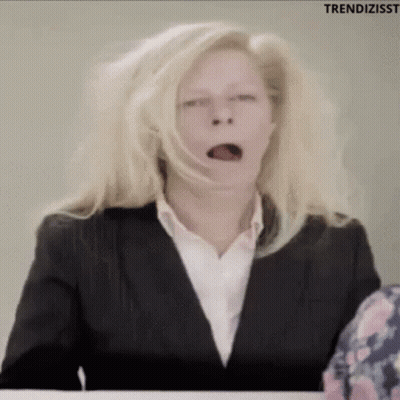 Woman In Suit Yawning At Desk GIF