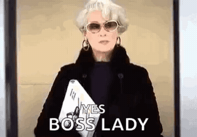 Woman In Sunglasses And Black Coat Holding Laptop And Paper GIF