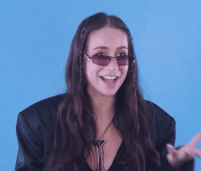 Woman In Sunglasses And Black Jacket Laughing GIF