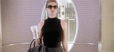 Woman In Sunglasses And Black Top Holding Coffee And Purse GIF