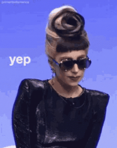Woman In Sunglasses And Black Top With Flower Saying Yep GIF