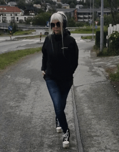 Woman In Sunglasses And Headphones Walking GIF