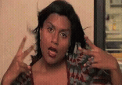 Woman In Sunglasses And Hoodie Sitting In Crowd GIF