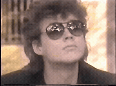 Woman In Sunglasses And Mullet Looking Up At Sky GIF