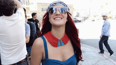 Woman In Sunglasses And Red Blue Necklace Smiling GIF
