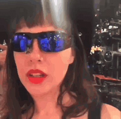 Mujer con gafas de sol y lápiz labial rojo mirando a la cámara GIF