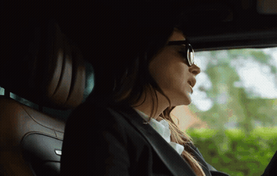Woman In Sunglasses And Suit Driving Car GIF