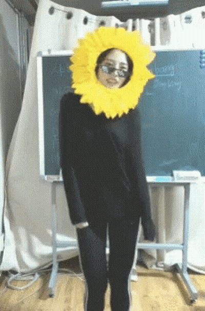 Woman In Sunglasses And Sunflower Hat With Hong Kong Blackboard GIF