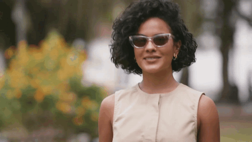 Woman In Sunglasses And Tan Dress Smiling GIF