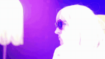 Woman In Sunglasses And White Wig Against Purple Background GIF
