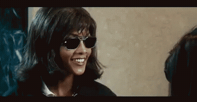 Woman In Sunglasses And Wig Smiling Talking To Another Woman GIF