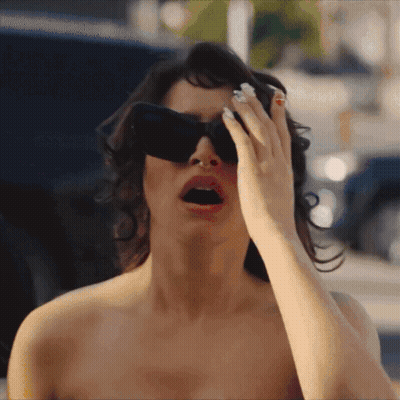mujer con gafas de sol cubriéndose los ojos con la mano GIF