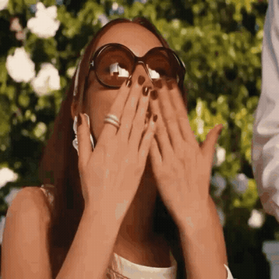 Woman In Sunglasses Covering Mouth GIF