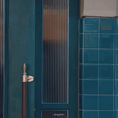 Woman In Sunglasses In Front Of Blue Door GIF