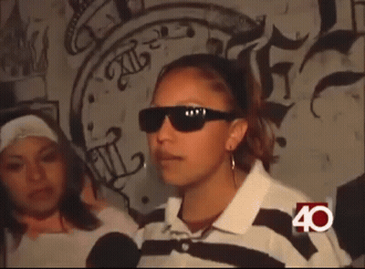 Woman In Sunglasses In Front Of Graffiti Wall GIF