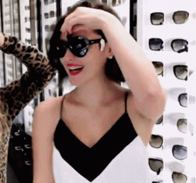 Woman In Sunglasses In Front Of Row Of Sunglasses GIF