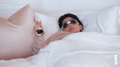 Woman In Sunglasses Lying On Bed With Legs Crossed GIF