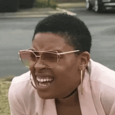 Woman In Sunglasses Making Funny Face On Grass GIF