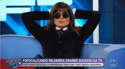 Woman In Sunglasses Sitting On Couch With Hands Behind Head In Front Of SBT Logo GIF