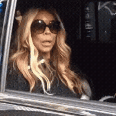 Woman In Sunglasses Surprised In Car GIF