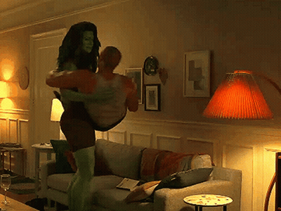 Woman In Superhero Costume Carrying Man GIF
