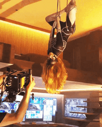Woman In Superhero Costume Hanging Upside Down GIF