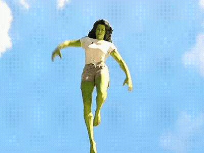 Woman In Superhero Costume Jumping With Arms Outstretched GIF