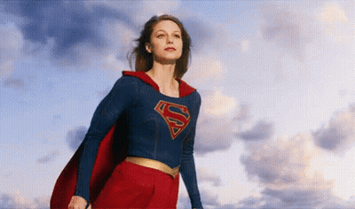 Woman In Superman Costume Against Cloudy Blue Sky GIF