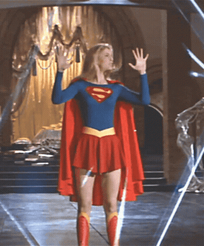 Woman In Superman Costume Before Chandelier GIF