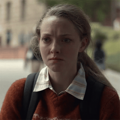 Woman In Sweater And Backpack Looking At Camera GIF