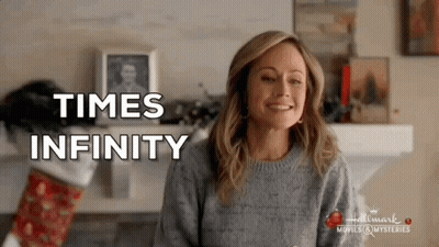 Woman In Sweater Smiling By Fireplace Times Infinity GIF