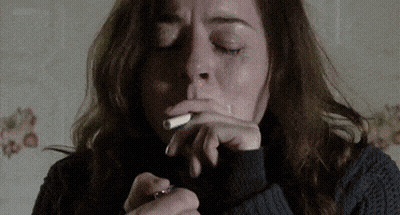 Woman In Sweater Smoking Cigarette GIF