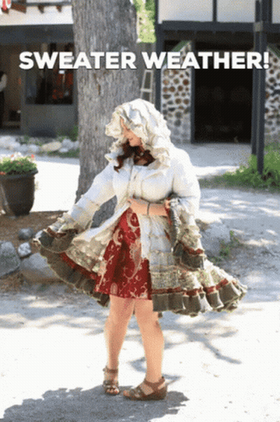 Woman In Sweater Weather Outfit Standing On Street GIF