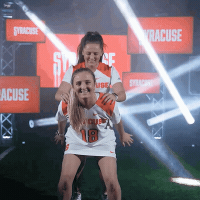 Woman In Syracuse Jersey Carrying Another Woman GIF