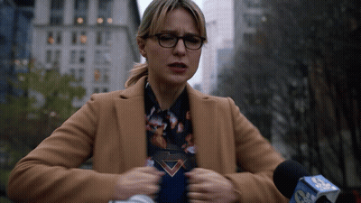 Woman In Tan Coat Speaking Into CBS Microphone GIF