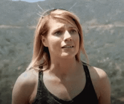 Woman In Tank Top Standing In Front Of Mountain GIF